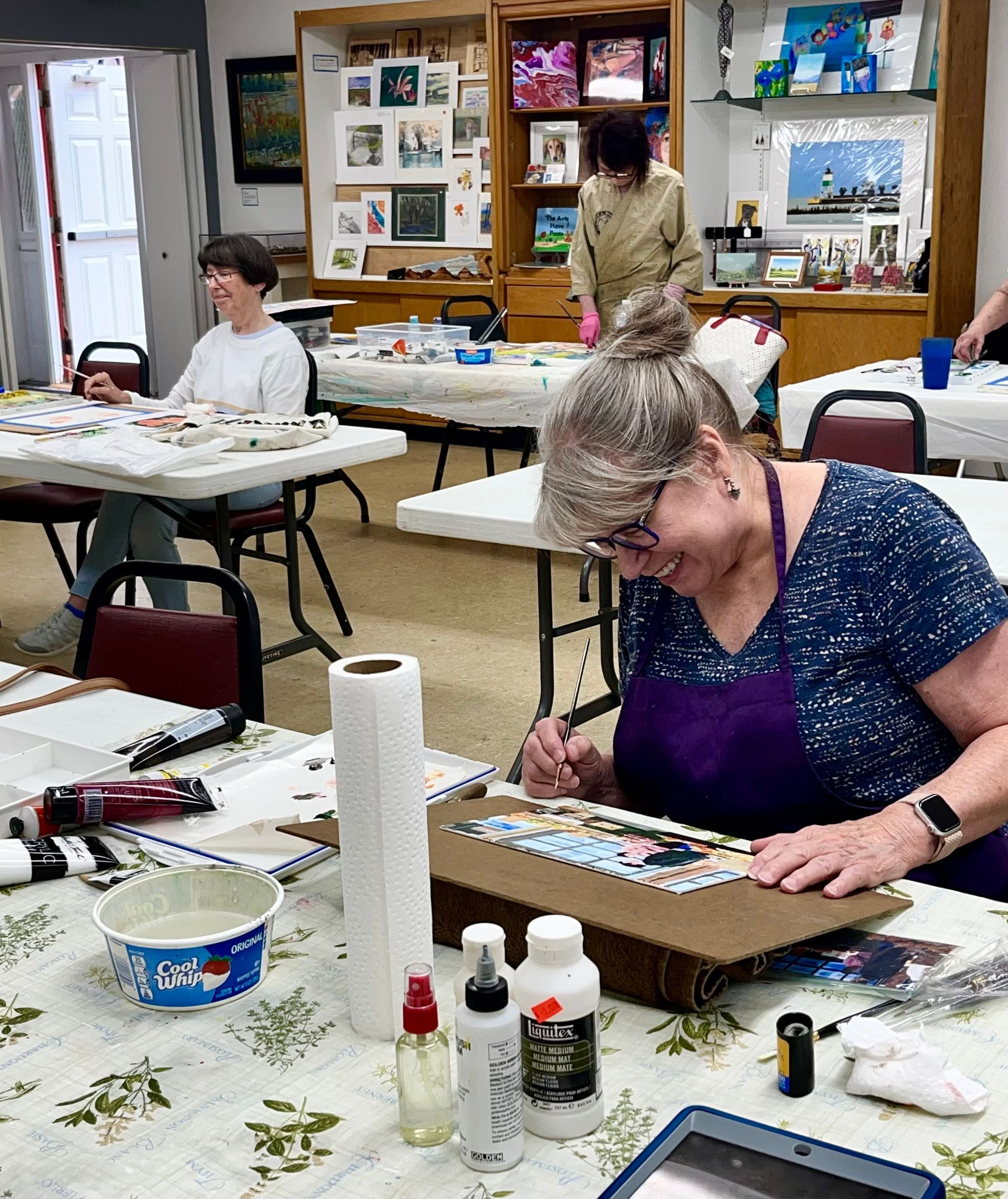 A table with a painting and a laptop on it