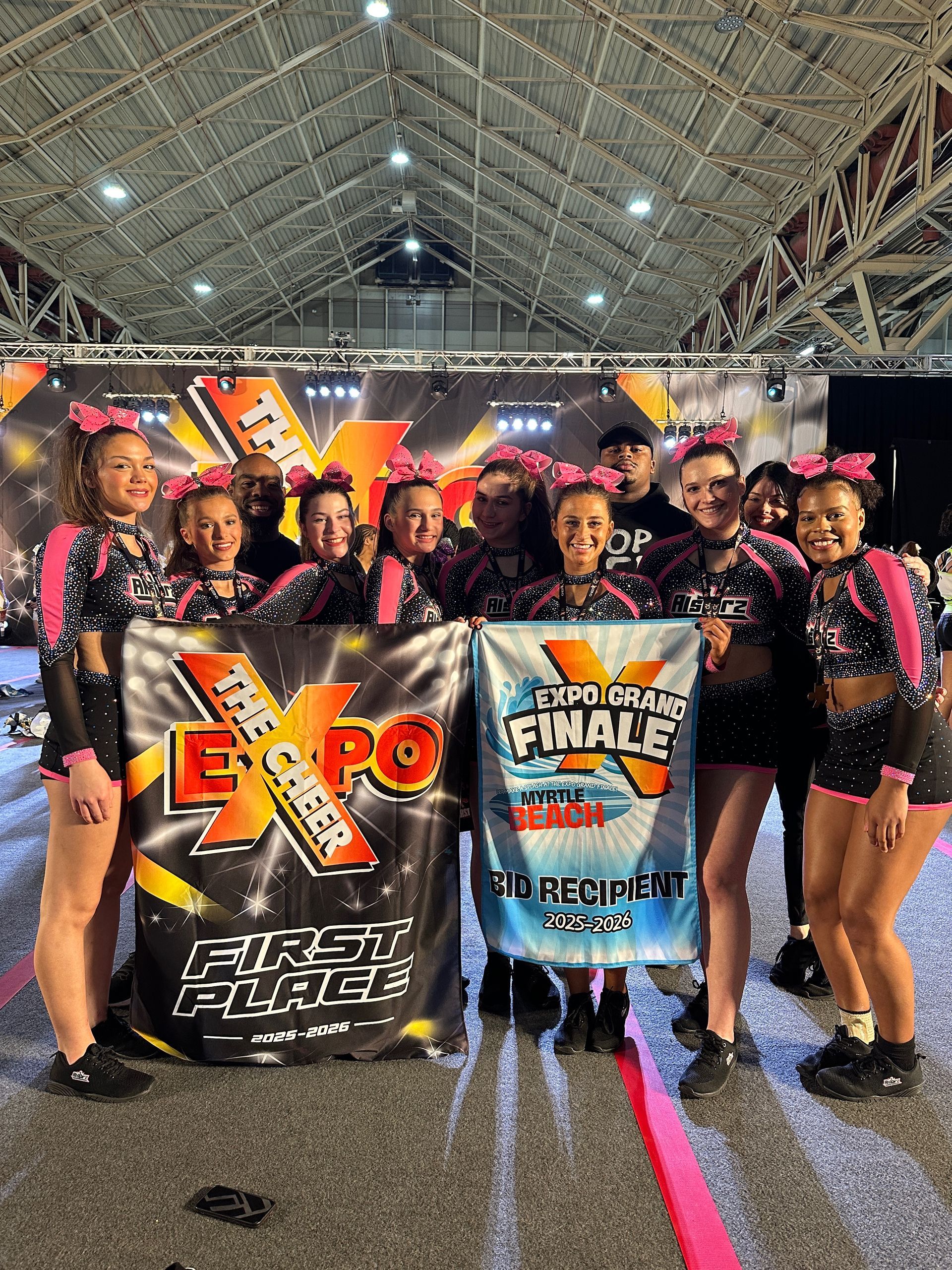 A group of cheerleaders are performing in front of a sign that says spirit