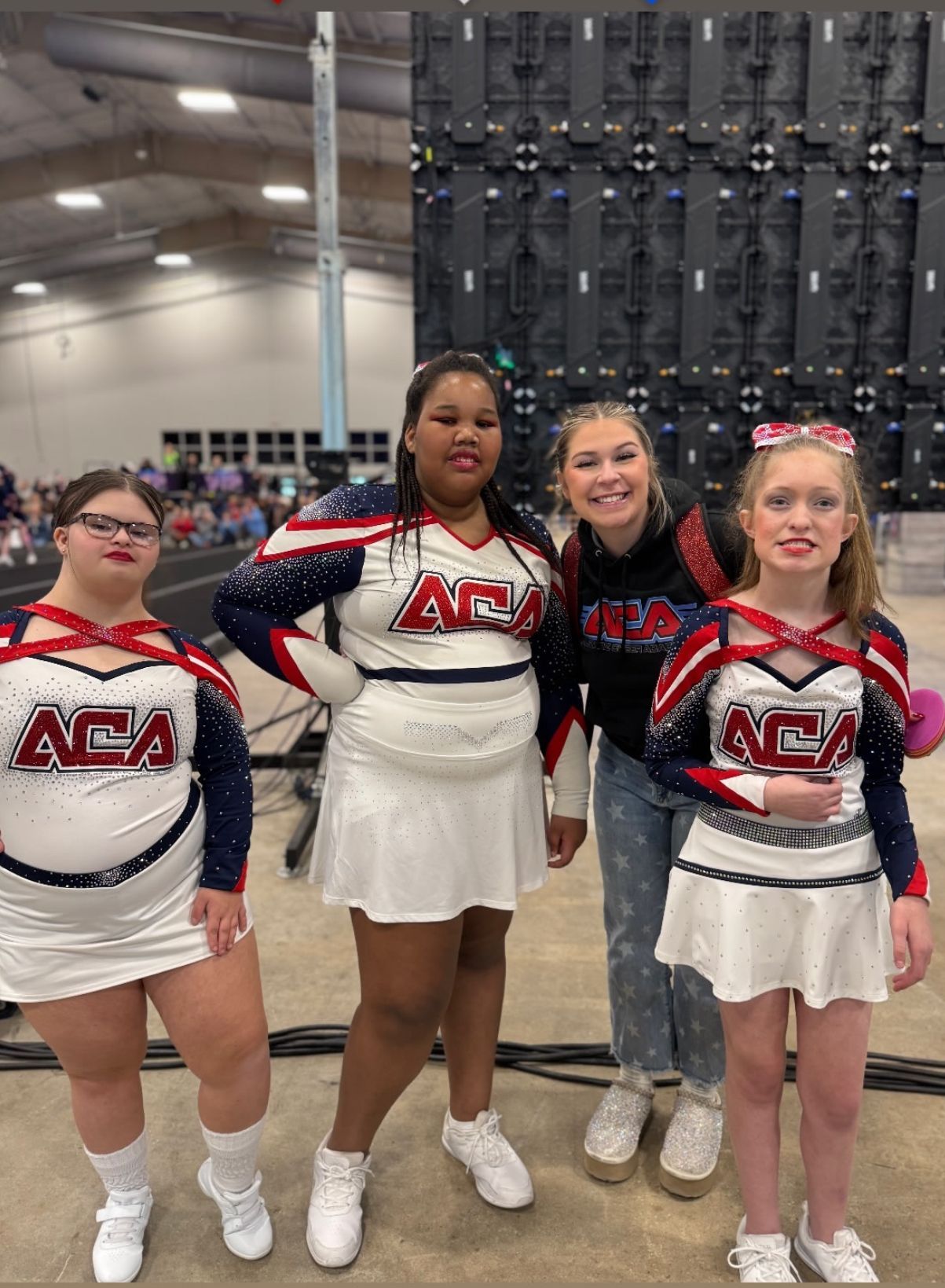 A group of cheerleaders are posing for a picture in a gym.