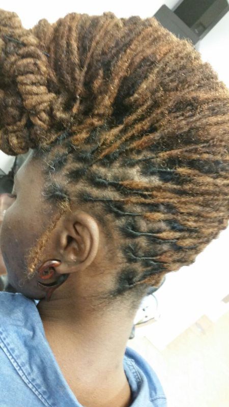 Close-up of a braided hairstyle with twisted brown and black extensions in profile.