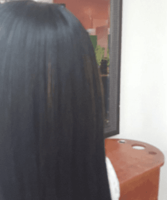 Back of a person with long dark hair near a doorway and a brown stool