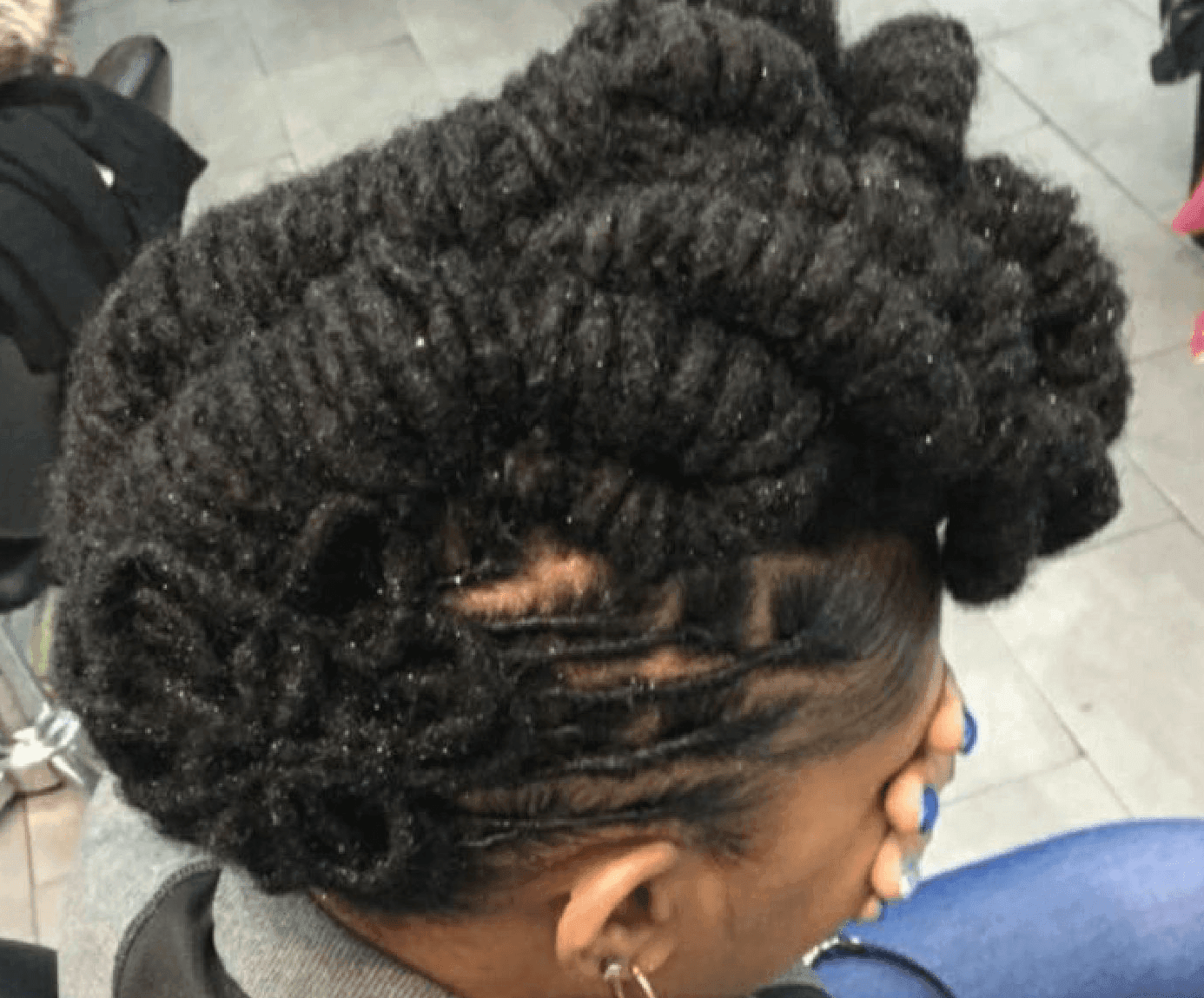 Close-up of a braided updo hairstyle with twisted sections and loose curls at the nape