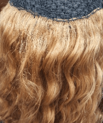 Close-up of wavy blonde hair beneath a dark blue knit cap