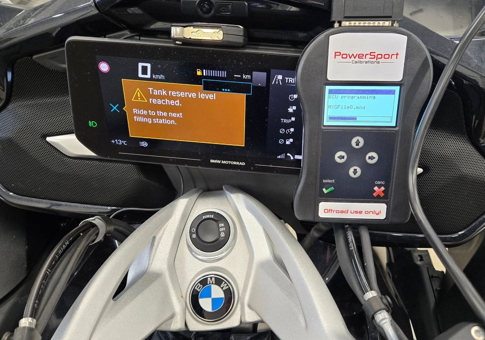 BMW steering wheel with dashboard display and PowerSport device showing a warning message