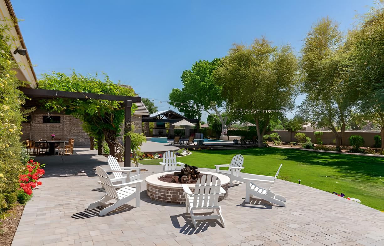 A fire pit surrounded by chairs in a backyard