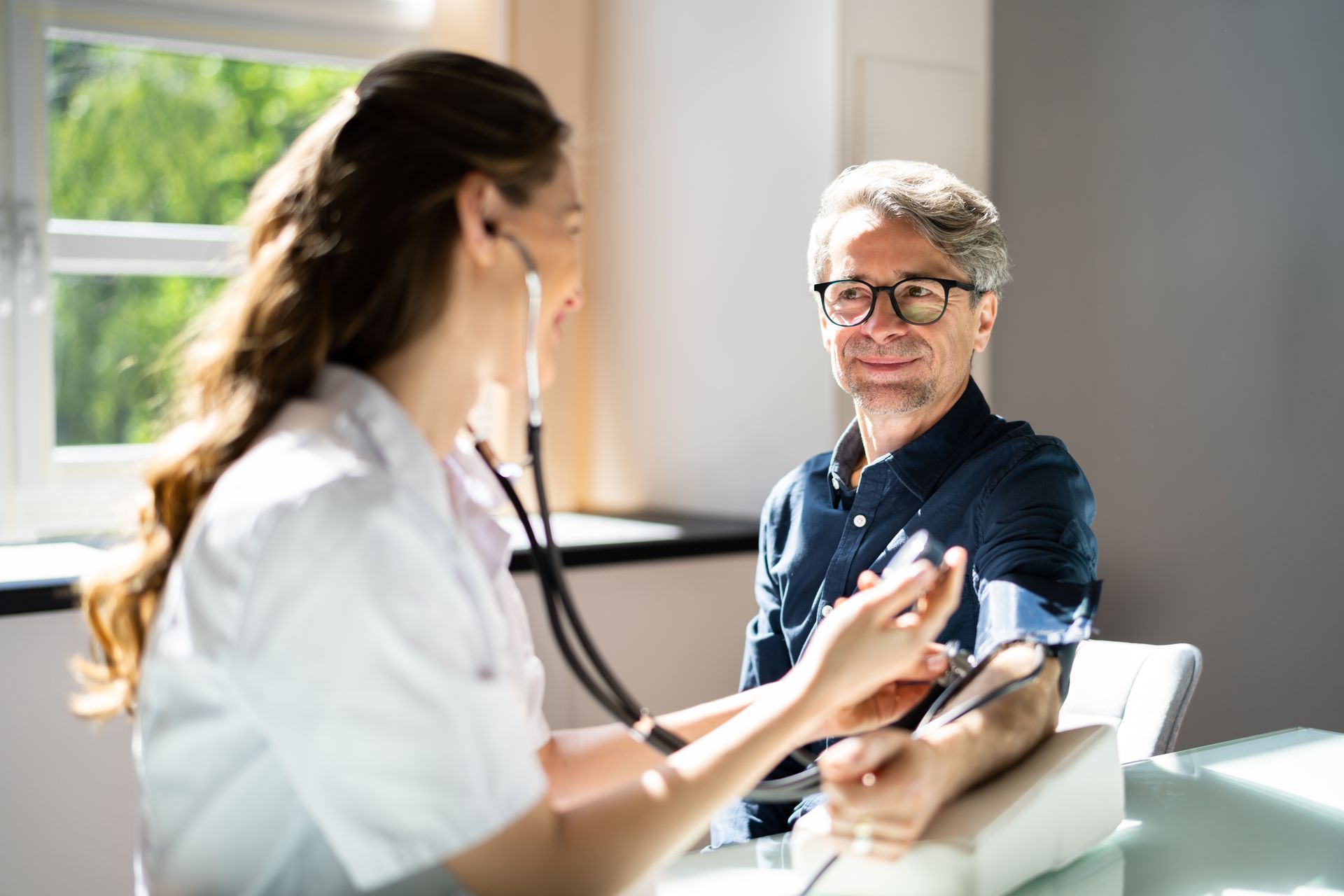 Doctor examining a patient’s arm in a bright clinic room