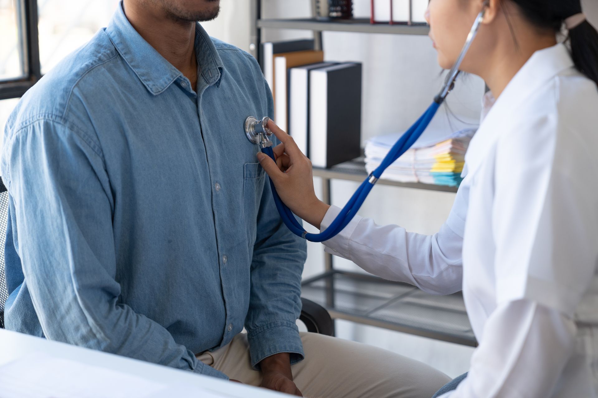 Doctor examining a patient with a stethoscope in a clinic