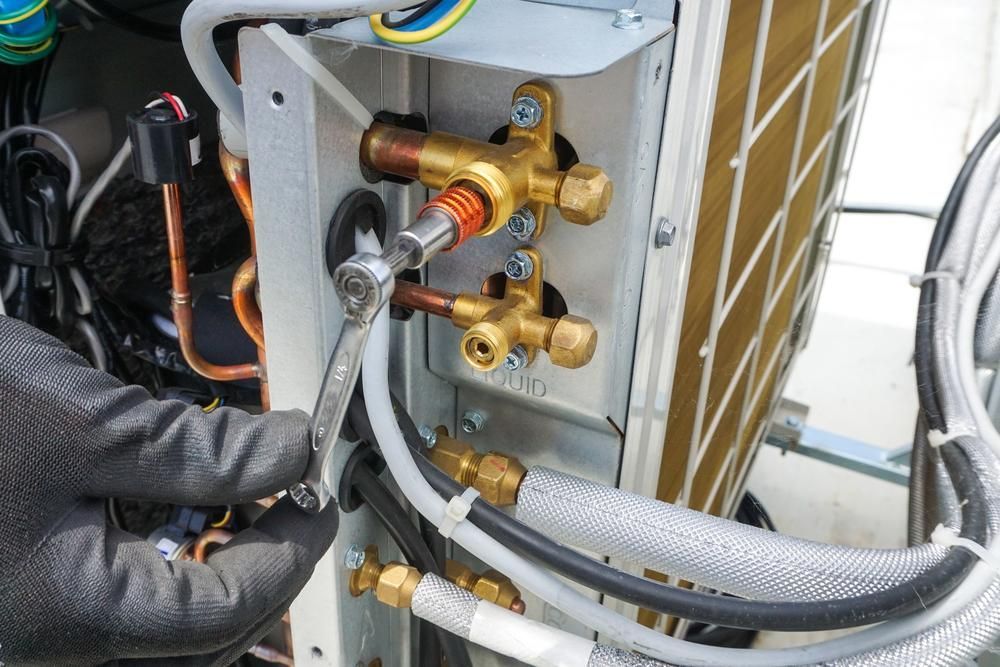 Gloved Hand Using a Wrench on an Ac Unit's Valve Fittings — ABV Plumbing In Umina Beach, NSW