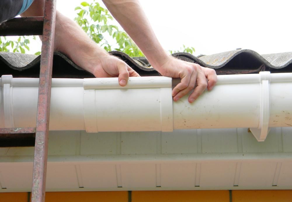 Person Connecting White Plastic Gutter Sections on a Roof — ABV Plumbing In Woy Woy, NSW