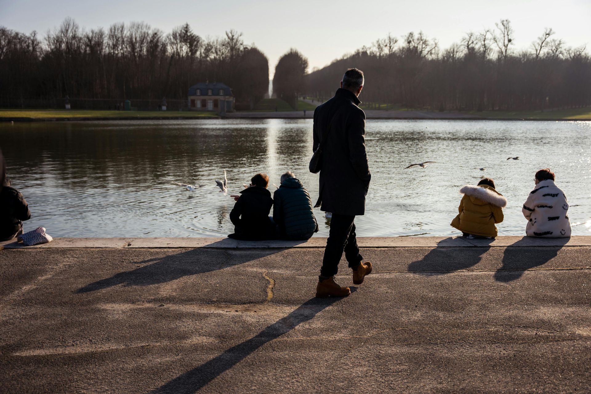 A group of people are sitting on the shore of a lake.