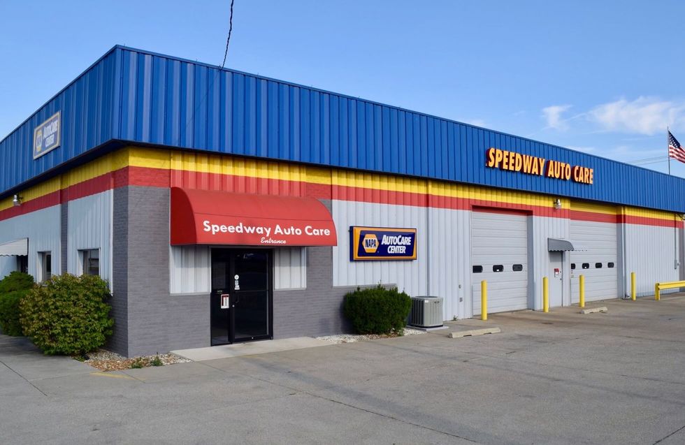 Speedway auto care shop exterior with blue roof, red awning, and garage doors | Speedway Auto Care