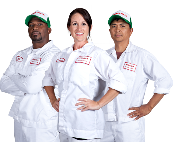 A man and two women wearing white overalls and green hats