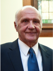 A man in a suit and tie is smiling for the camera