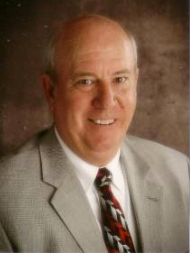 A man in a suit and tie is smiling for the camera.
