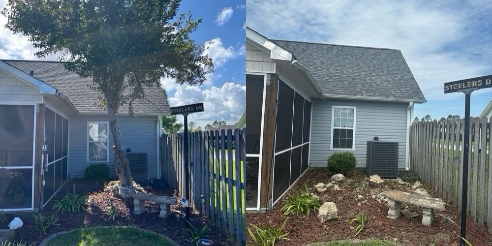 Small gray shed beside a fenced garden with stone edging and a tree