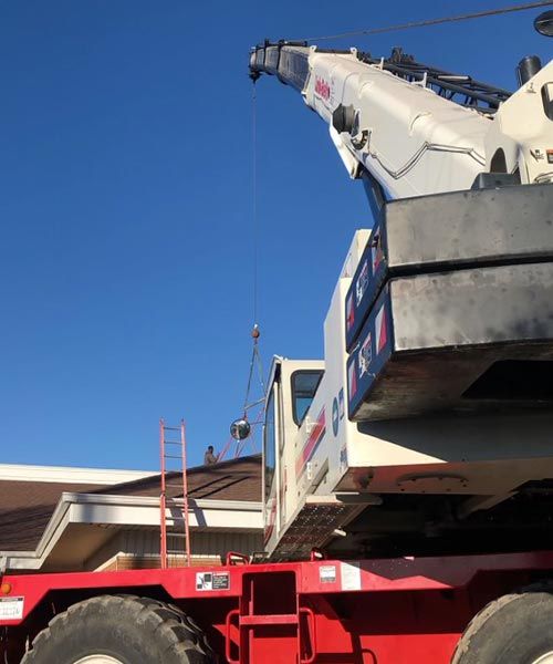 crane lifting shingles at residential construction