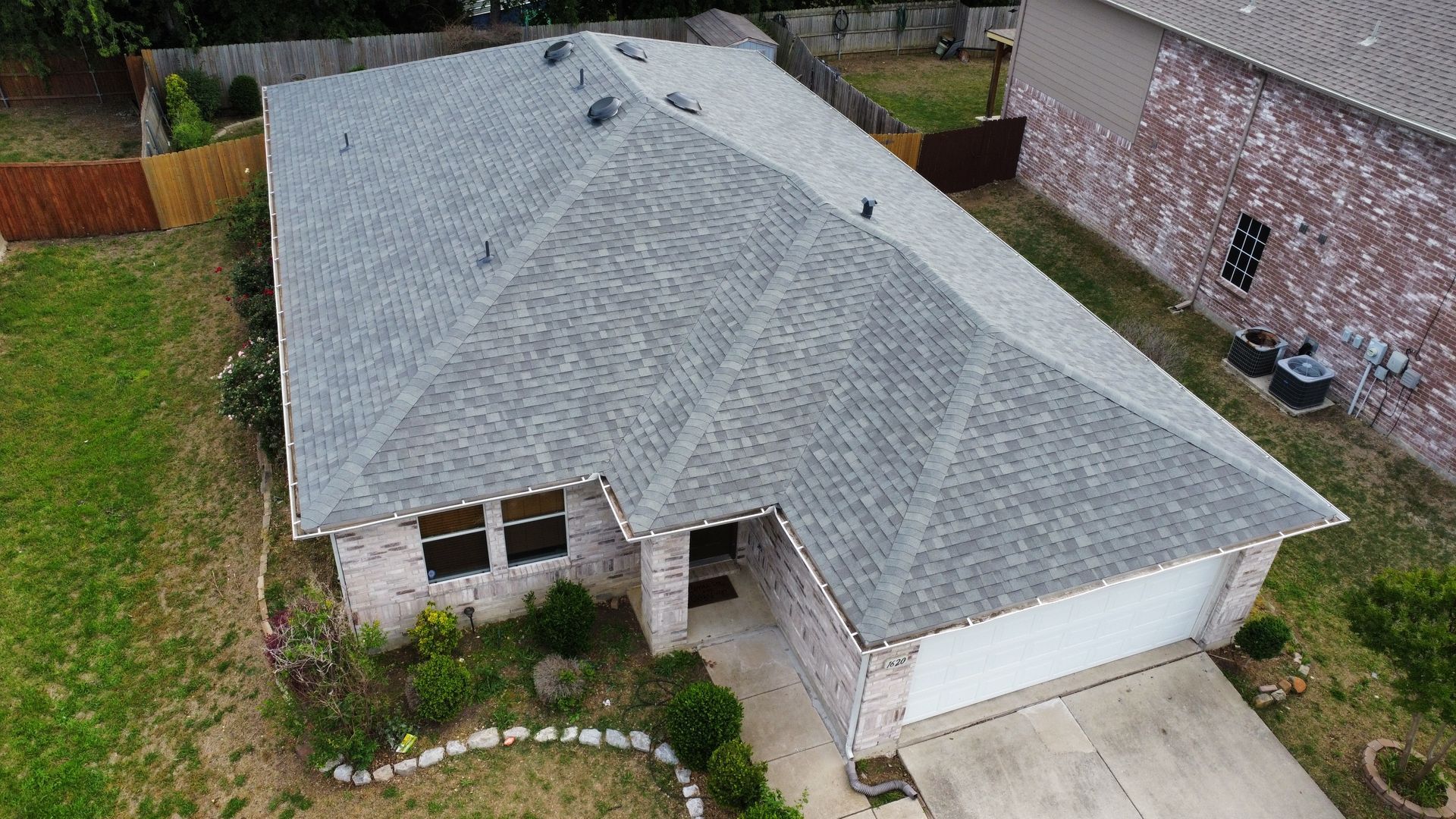 An aerial view of a house with a new roof.