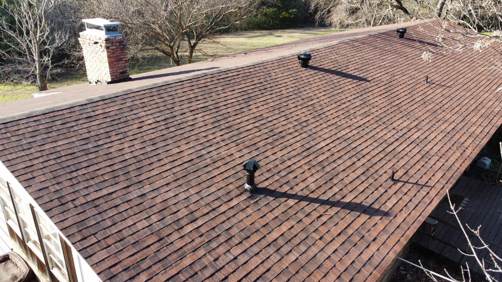 A roof of a house with a chimney on top of it.