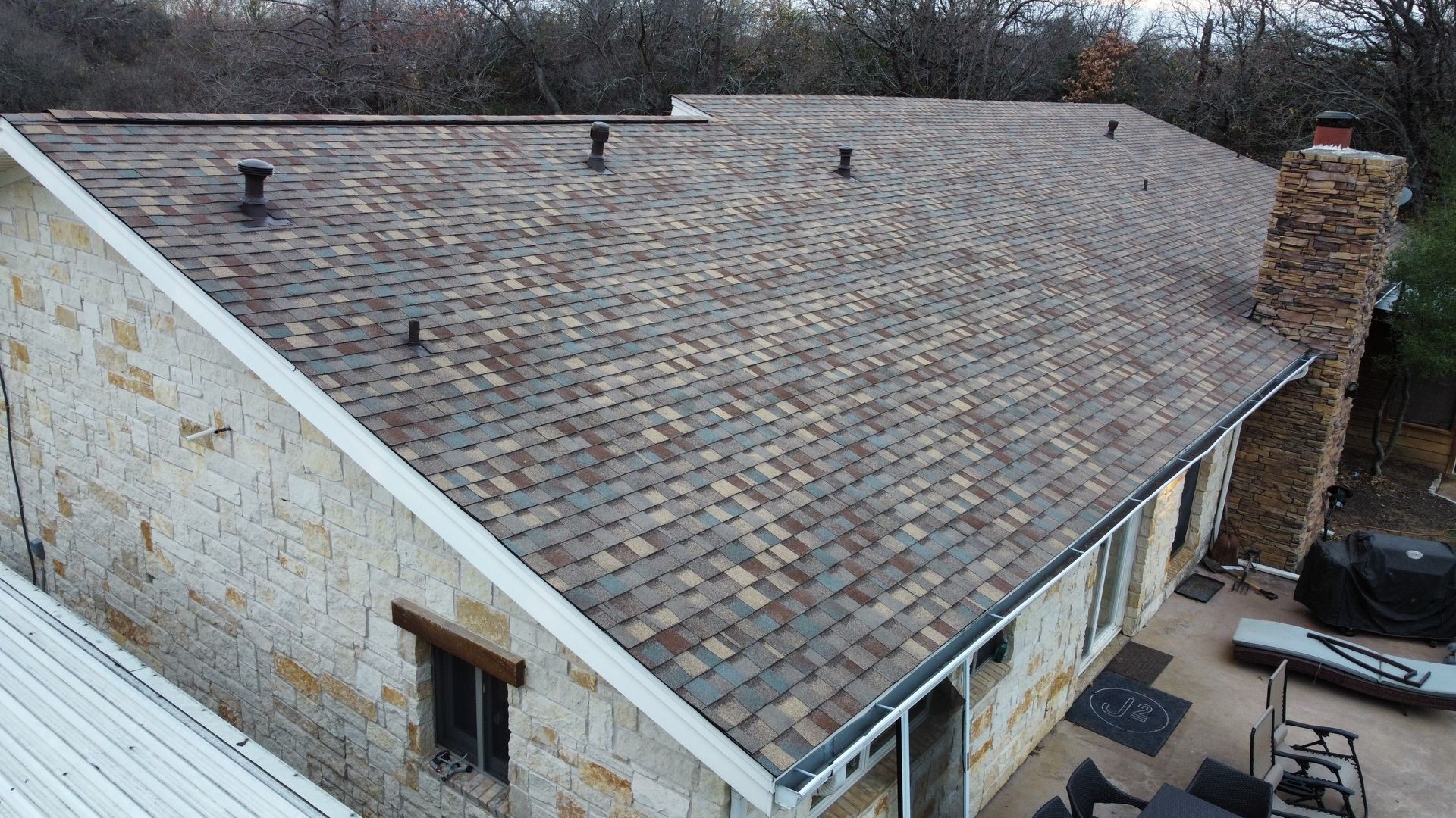 An aerial view of a house with a roof and a chimney.