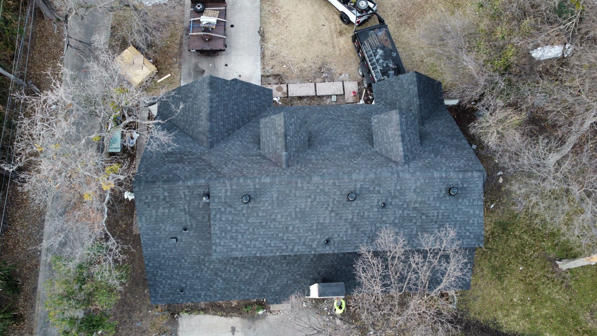 An aerial view of a large house with a black roof.