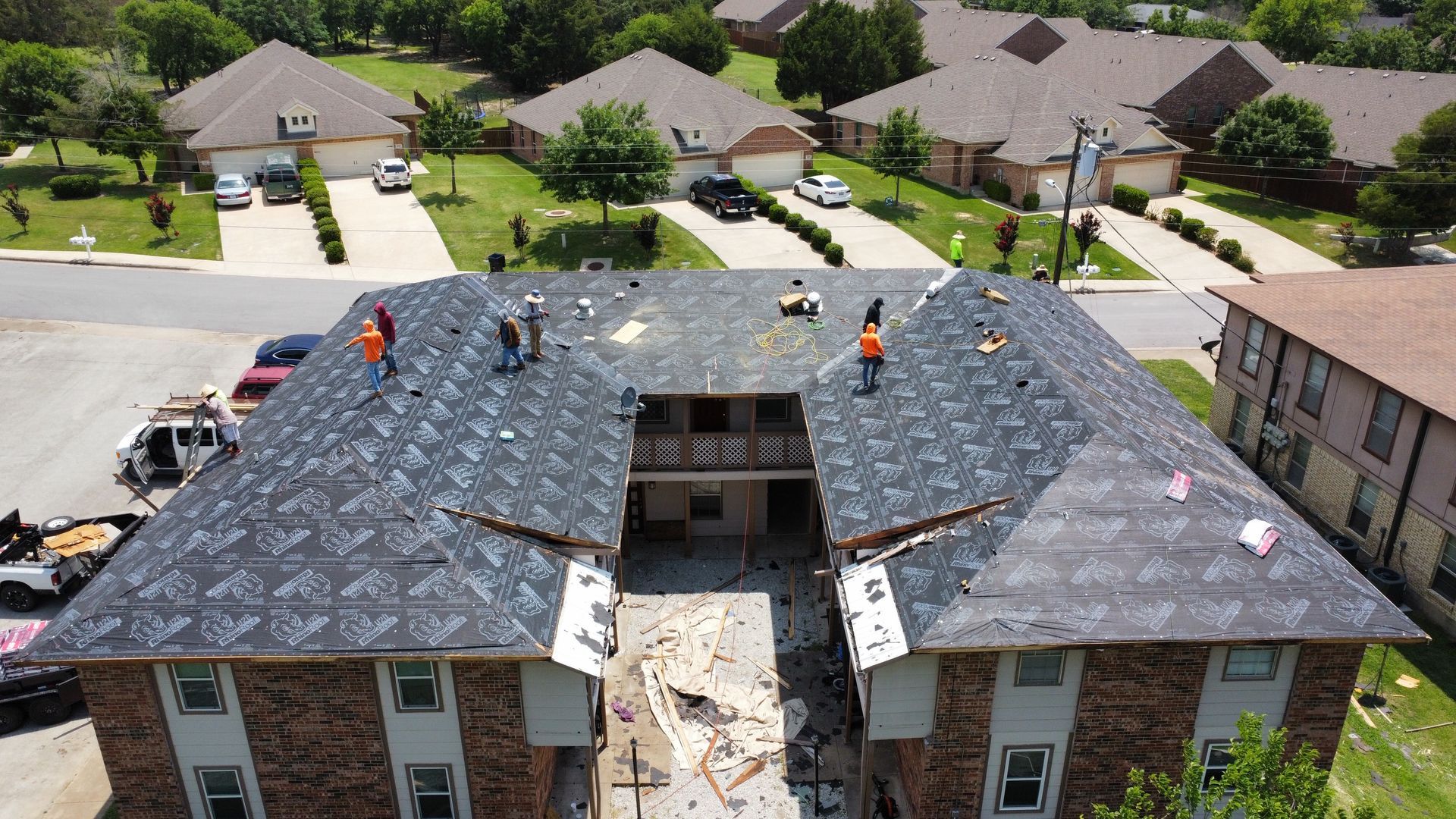 A group of people are working on the roof of a building.
