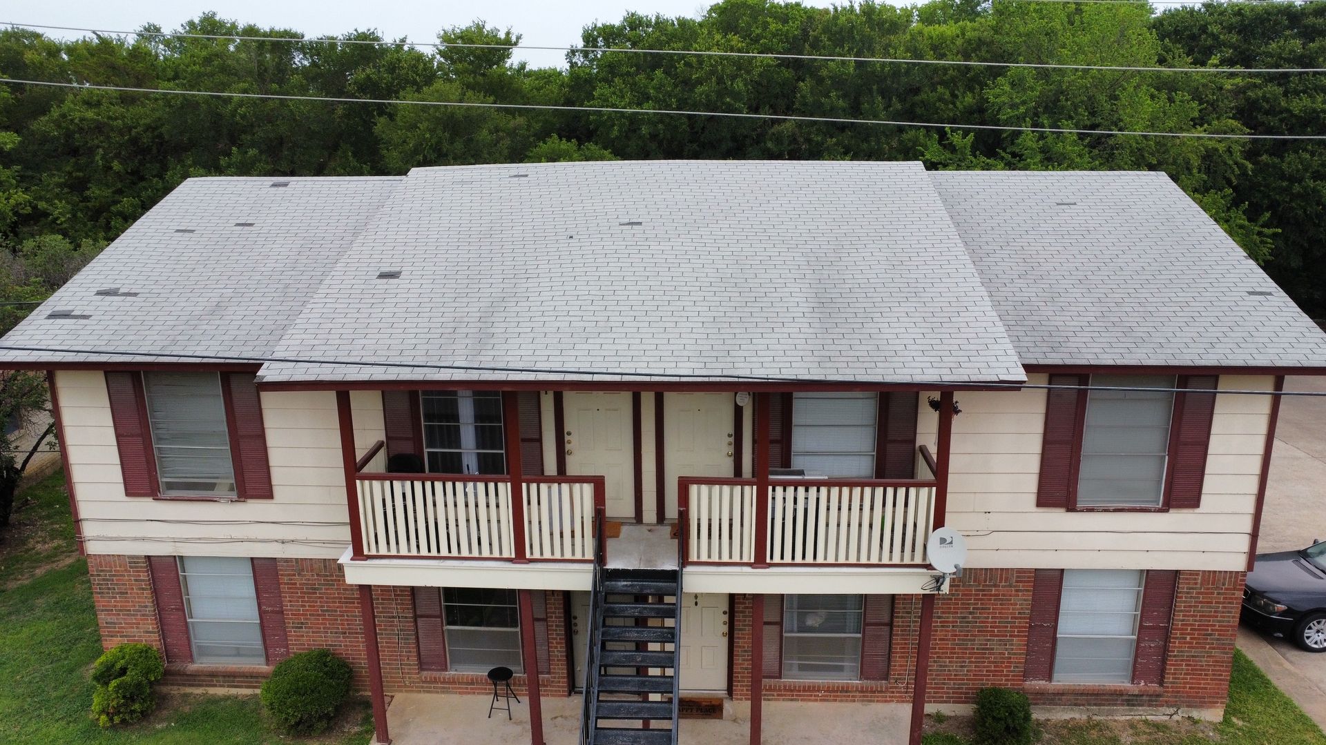 An aerial view of a brick apartment building with a car parked in front of it.