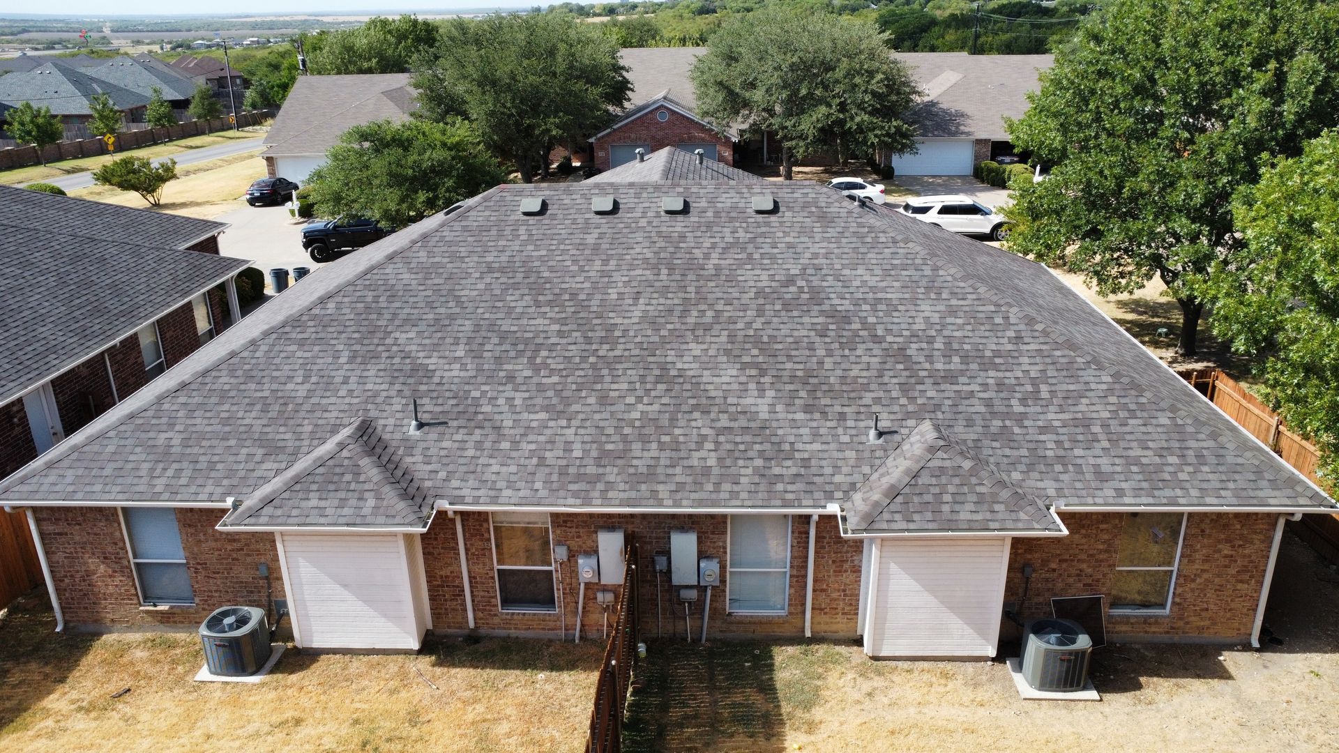 An aerial view of a row of houses with a gray roof.