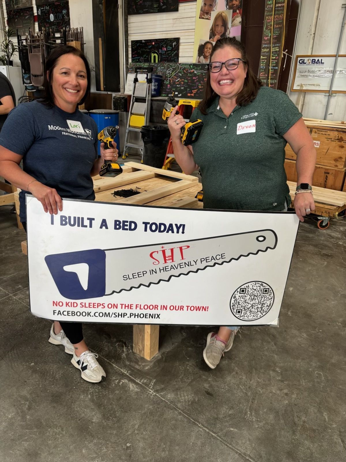 Two FFLC volunteers with tools and a Sleep in Heavenly Peace sign