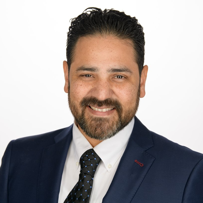 A man in a suit and tie is smiling for the camera.