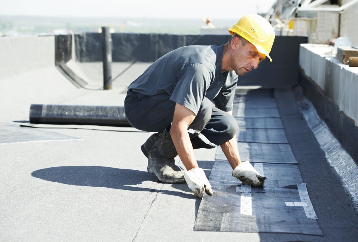 Roofing technician providing commercial roof maintenance guidance