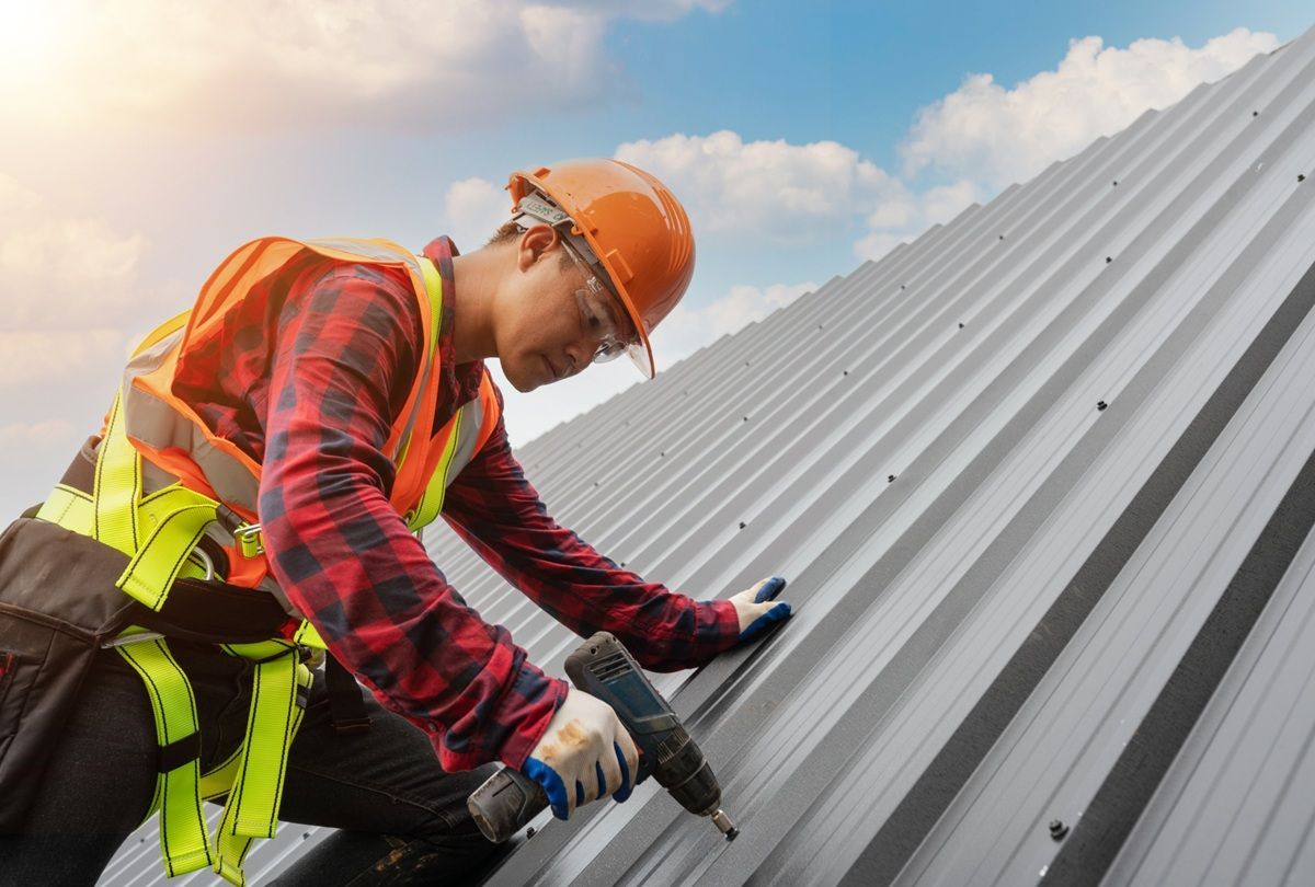 Roofing professionals installing metal roofing on a home in Los Banos