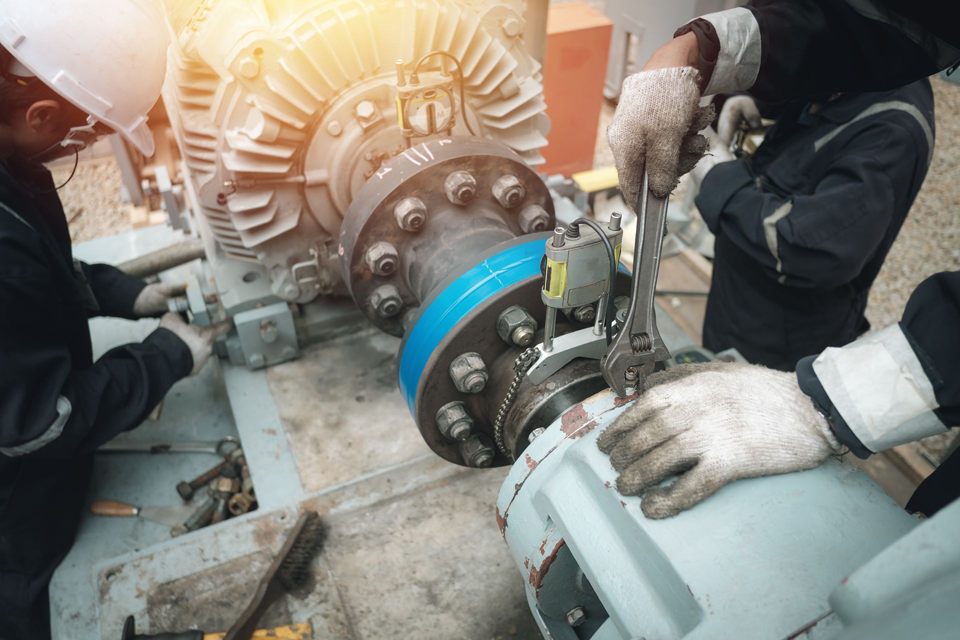 two men are working on a machine in a factory .