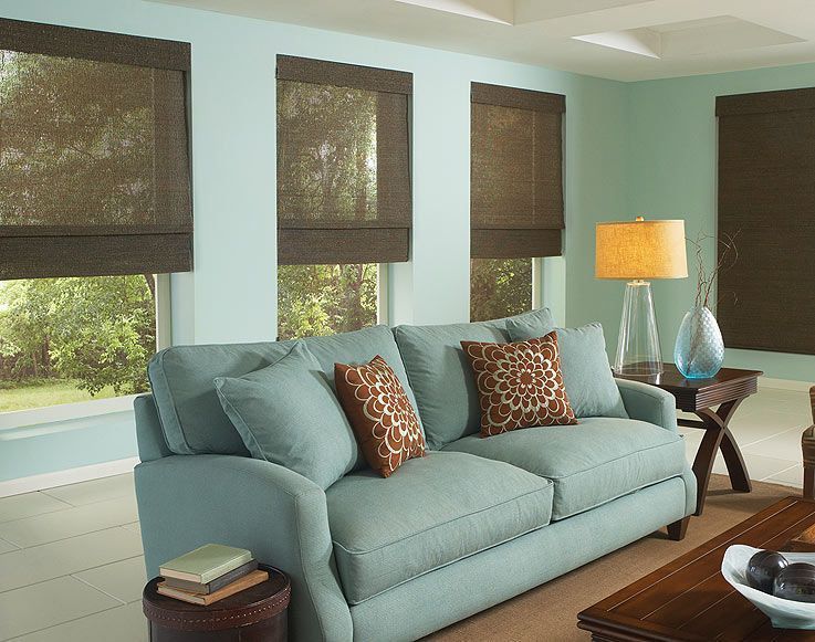 Living room with blue sofa, brown blinds, and a side table.