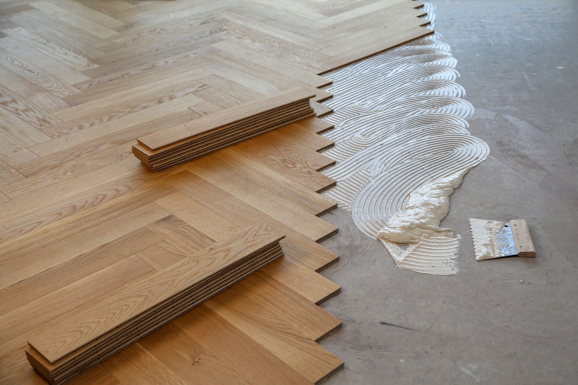 Wooden and white interlocking art pieces arranged on a floor, forming a wave-like pattern