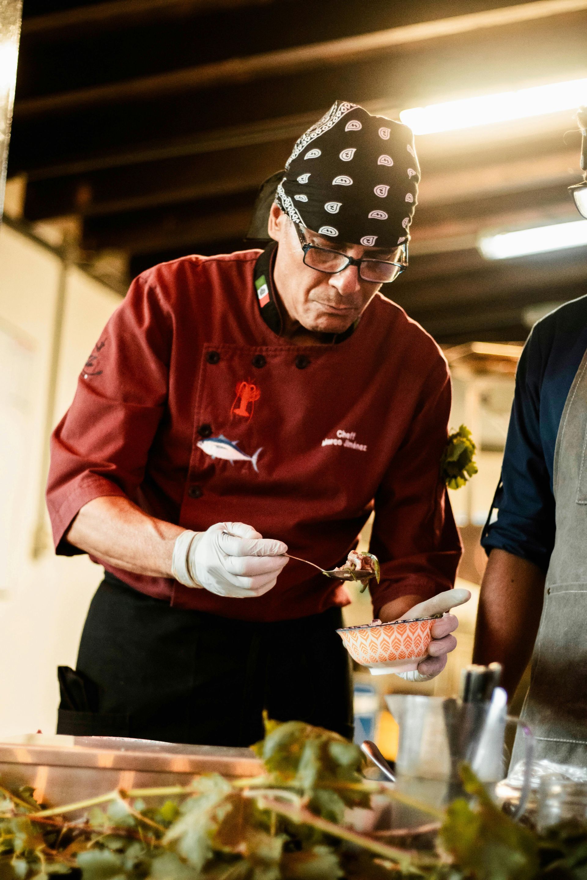 A man in a chef 's uniform is preparing food in a kitchen.