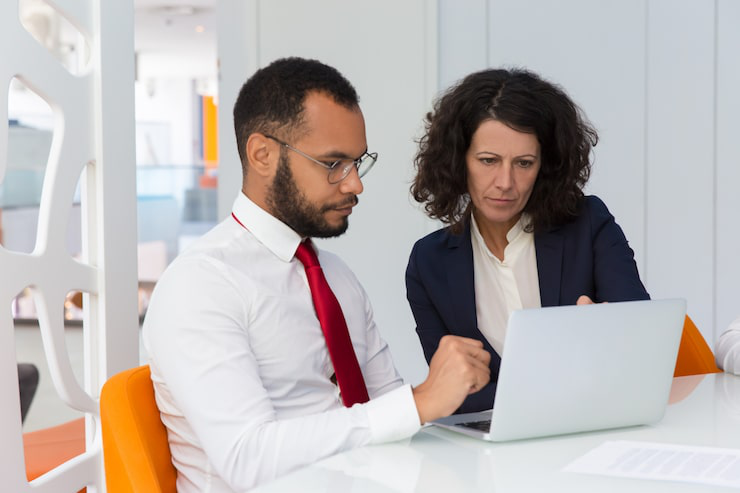 Business leaders reviewing contracts and discussing company strategy during a meeting.