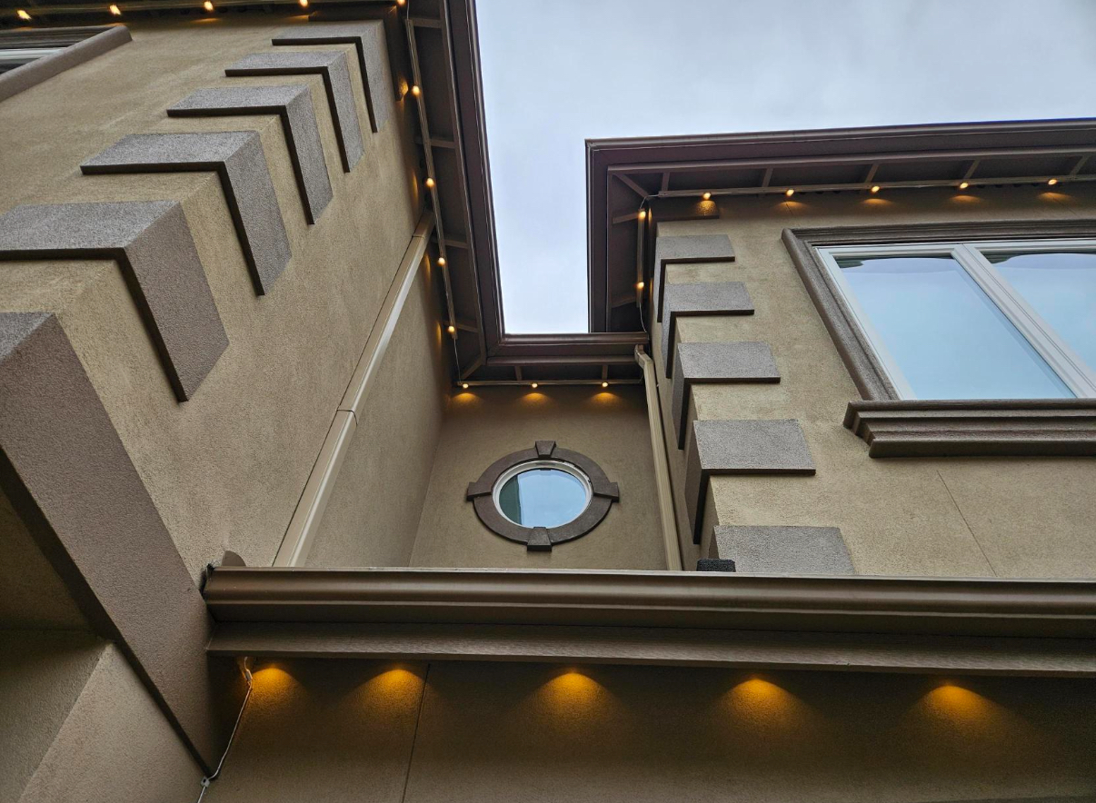 Warm white architectural lights installed along the roofline of a multi-story home.