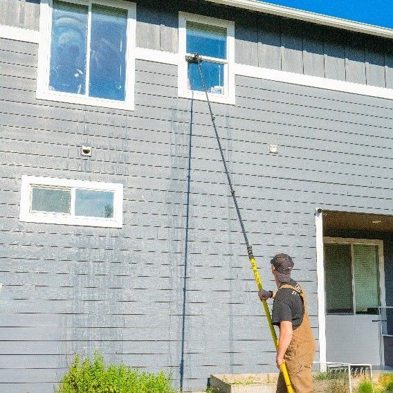 Window cleaning service specialist using advanced equipment to clean residential windows.