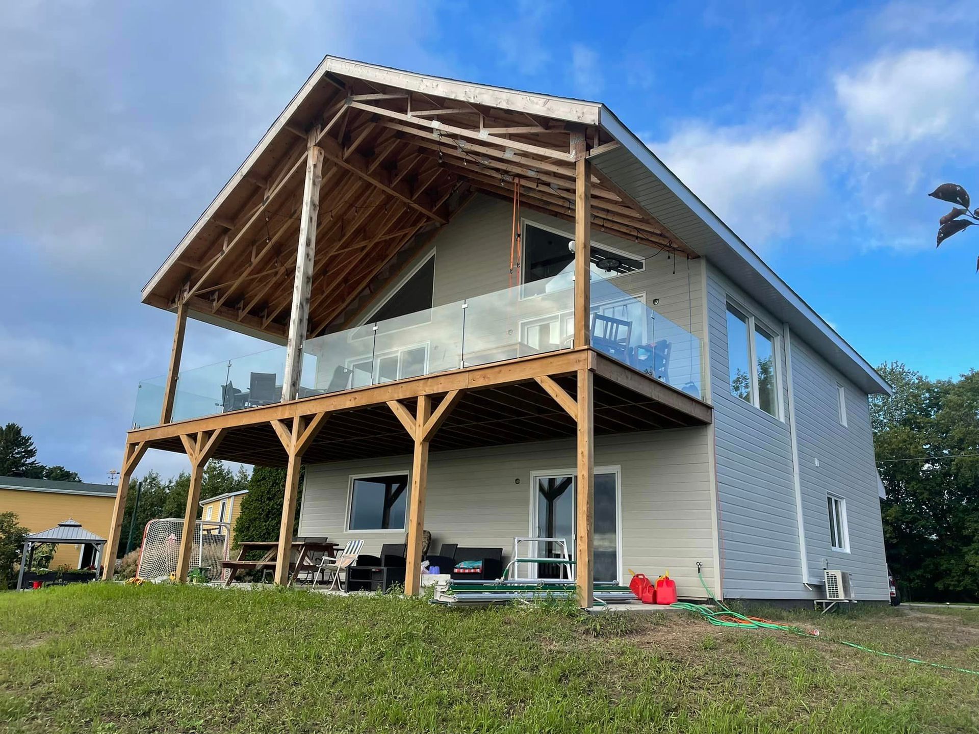 Une grande maison avec une grande terrasse au dessus.