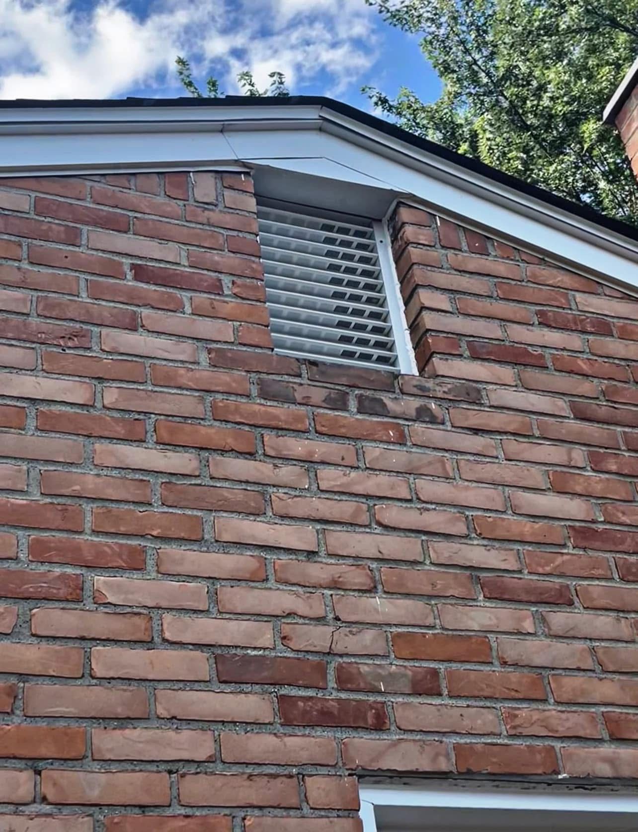 A brick patio with a herringbone pattern in front of a brick house. A brick patio with a herringbone pattern in front of a brick house.