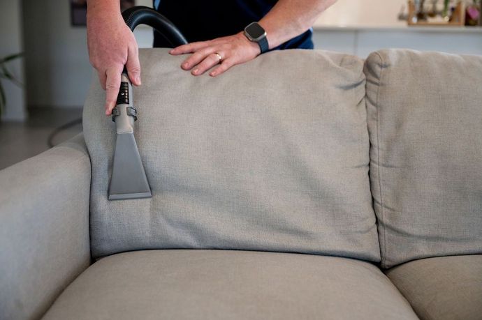 lounge cleaning man cleaning a grey lounge in a home
