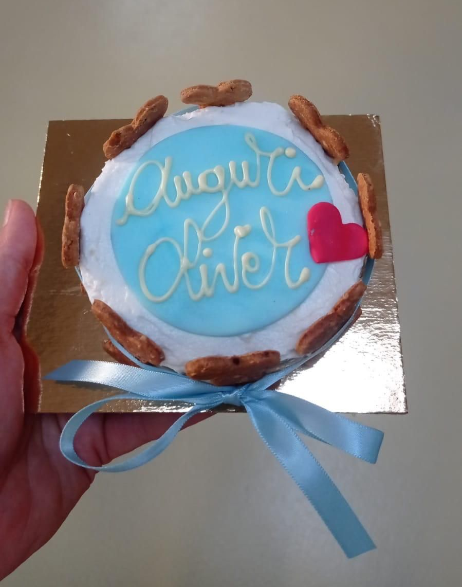 Viene tenuta una piccola torta su una superficie dorata, glassa azzurra,
