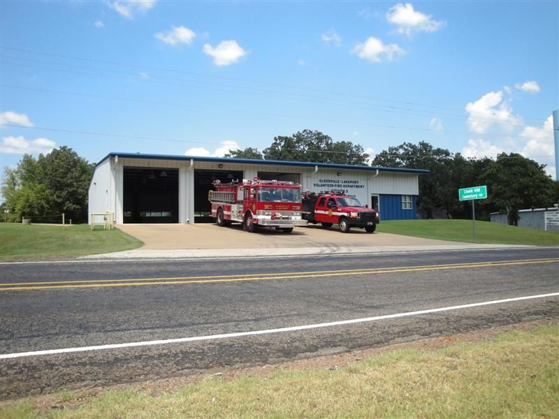 Two red fire trucks are parked in front of a building