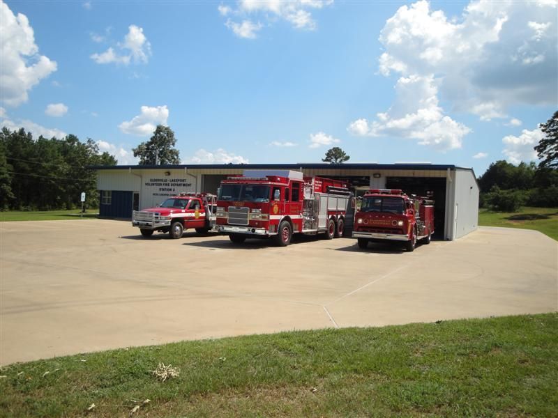 Three fire trucks are parked in front of a building