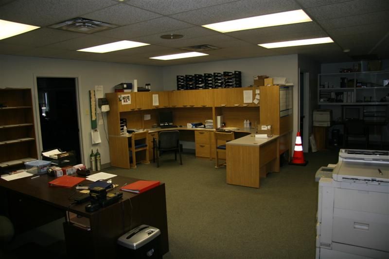 An office with a lot of desks and a printer
