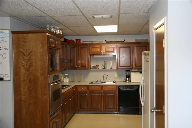 A kitchen with wooden cabinets and a black dishwasher