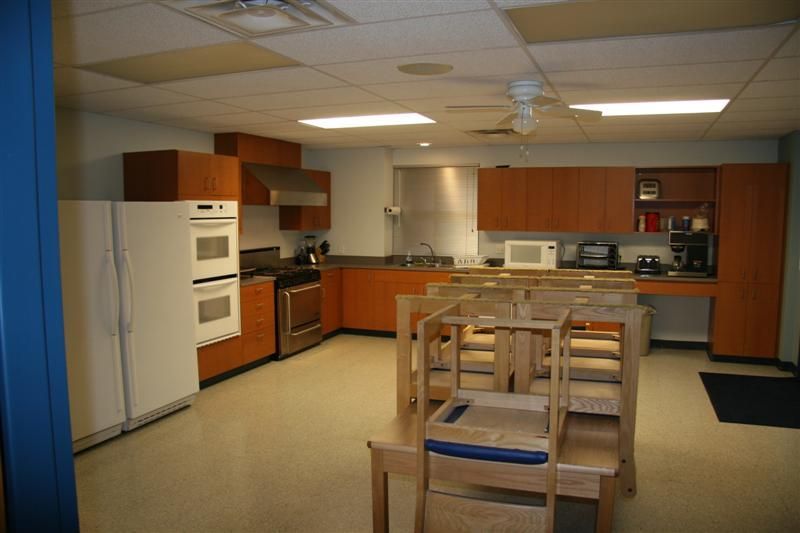 A kitchen with a table and chairs and a refrigerator