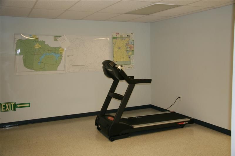A treadmill in a room with an exit sign on the wall
