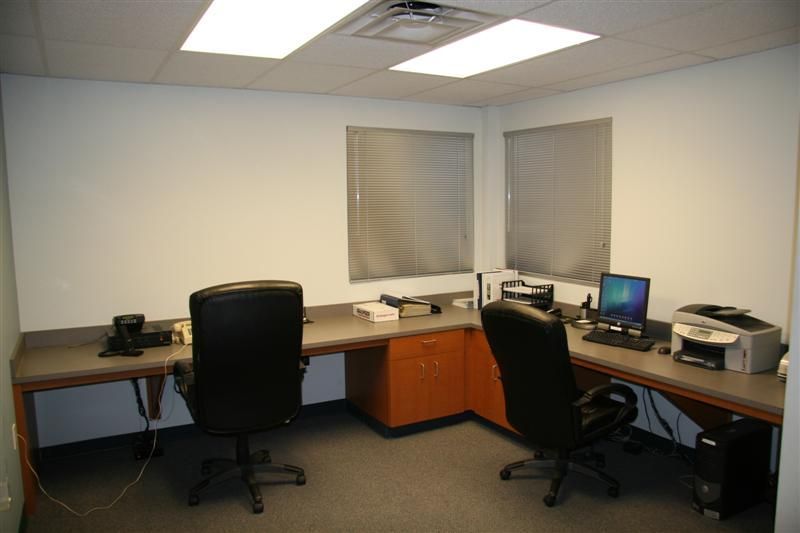 A small office with two desks and two chairs