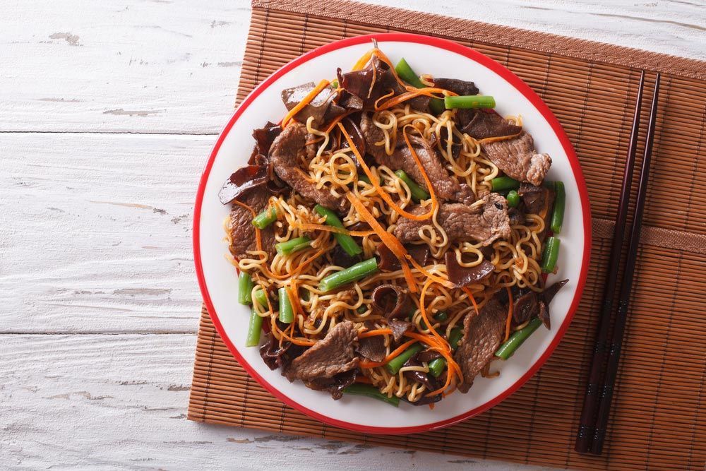A Plate Of Food With Chopsticks On A Table — One Thai Cuisine & Noodle Bar In Kirwan, QLD